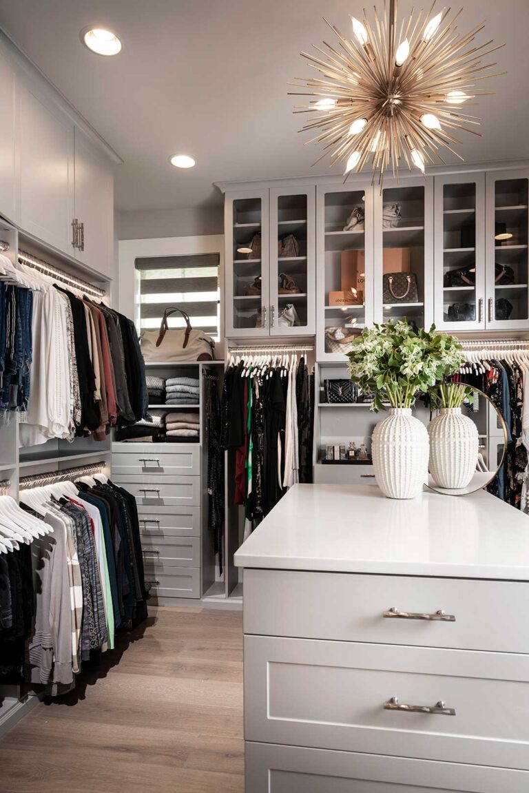 Custom closet design featuring glass doors and cabinetry