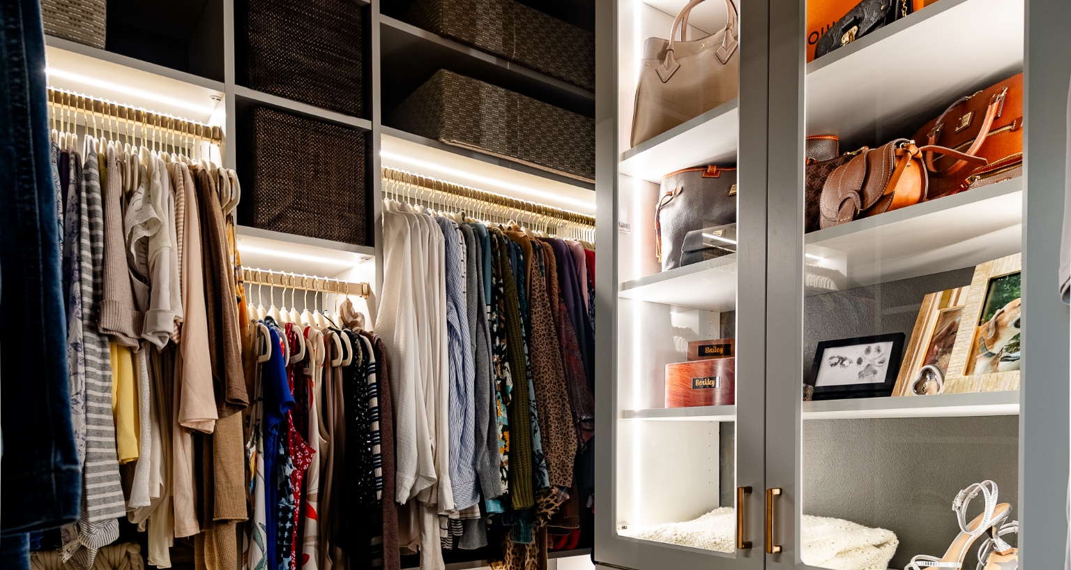 Smaller walk-in closet with organized beauty featuring lighted cabinetry